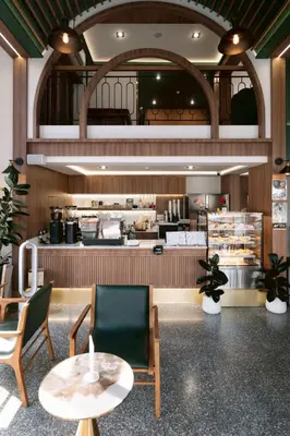a restaurant with chairs and a table and a counter at กรุงไทย โฮสเทล สเตชั่น in Thonhuri