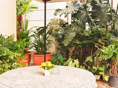 a white table with a vase of flowers on it at Danita's Home Bangkok in Bangkok
