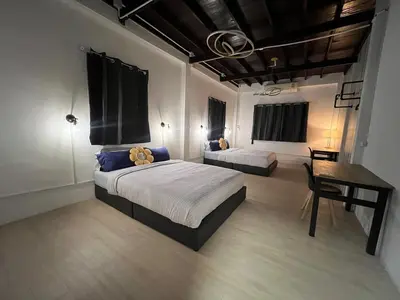 a bedroom with two beds and a desk in it at LA CASA in China town in Bangkok