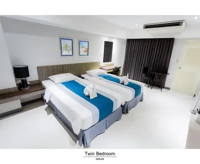 a hotel room with two beds and a desk at Pho Place in Bangkok