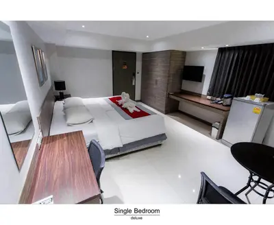 a bedroom with a large bed and a table at Pho Place in Bangkok