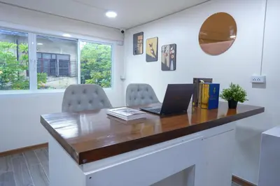 an office with a desk with a laptop and two chairs at Cozy KingsizeBed เจริญนคร