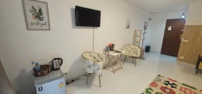 a living room with chairs and a television on a wall at Hotel pretty rooms in Pak Kret