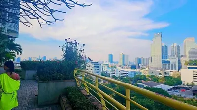 a person standing on a balcony looking at a city at River View Bangkok Apartment in Bangkok