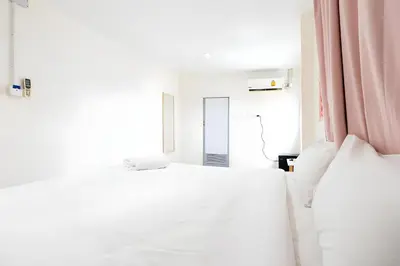 a white bedroom with a bed and a mirror at XX Oh My Nap Nana Soi 3 -โอมาย แนปเทล ซอย 3 in Makkasan