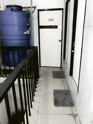 a staircase leading to a white door with a blue barrel at XX Oh My Nap Nana Soi 3 -โอมาย แนปเทล ซอย 3 in Makkasan