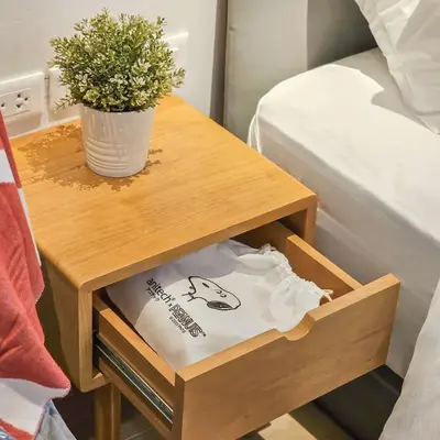 a small wooden table with a plant on it at Amina Residence in Ban Sai Ma