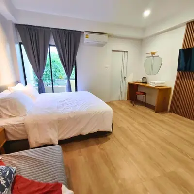 a hotel room with two beds and a desk at Amina Residence in Ban Sai Ma
