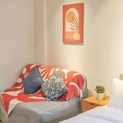 a living room with a couch with pillows on it at Amina Residence in Ban Sai Ma