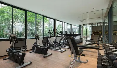 a gym with a row of treadmills and elliptical machines at 1 bed apartment at Phra Khnong in Bangkok