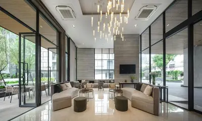 a large living room with couches and a chandelier at 1 bed apartment at Phra Khnong in Bangkok