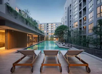 two chairs and a swimming pool in a building at 1 bed apartment at Phra Khnong in Bangkok