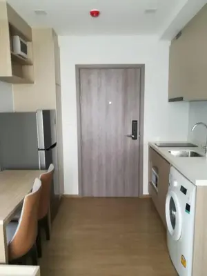 a kitchen with a door and a table and chairs at 1 bed apartment at Phra Khnong in Bangkok