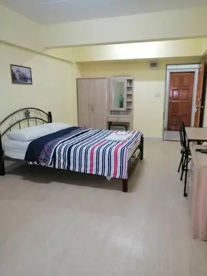 a bedroom with a bed with a striped blanket on it at KT MANSION Victory Monument in Bangkok
