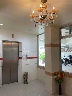 a lobby with a elevator and a chandelier at KT MANSION Victory Monument in Bangkok