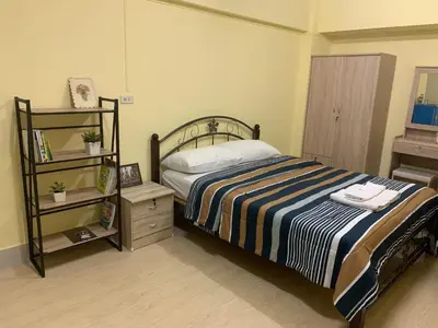 a bedroom with a bed and a book shelf at KT MANSION Victory Monument in Bangkok