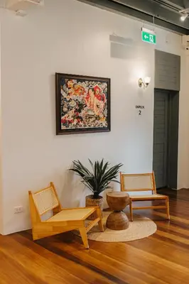 a living room with two chairs and a painting on the wall at Samranscape in Bangkok