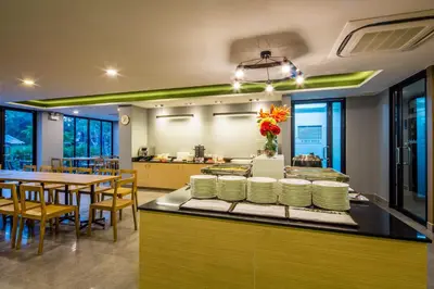 a restaurant with a counter with plates and tables at Livotel Hotel Kaset Nawamin Bangkok in Bangkok