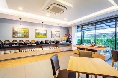 a restaurant with tables and chairs and windows at Livotel Hotel Kaset Nawamin Bangkok in Bangkok