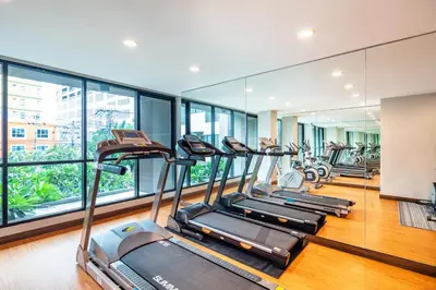 a row of treadmills in a gym with windows at Livotel Hotel Kaset Nawamin Bangkok in Bangkok