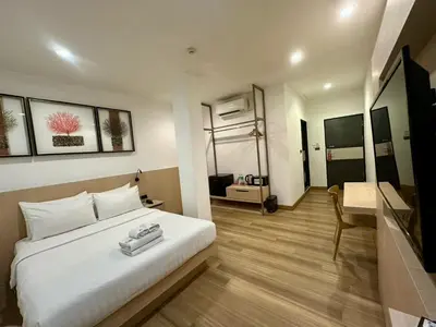 a bedroom with a large white bed and a desk at Sakura Sky Residence in Bangkok