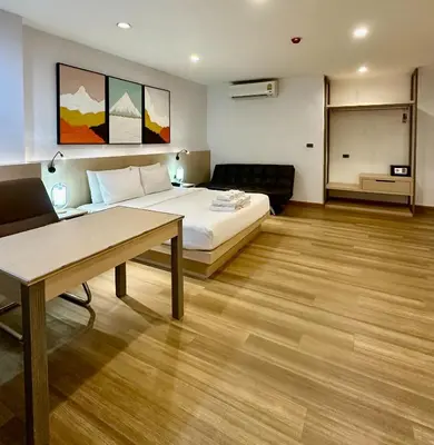 a hotel room with a bed and a table at Sakura Sky Residence in Bangkok