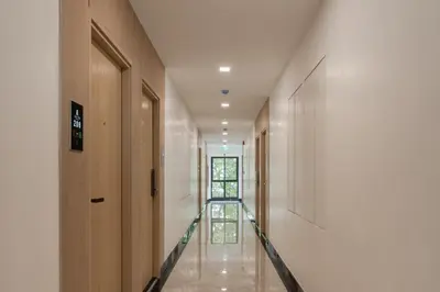 a hallway with wooden doors and a stair case at Solyn Hotel in Bangkok