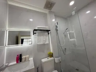 a white bathroom with a shower and a toilet at Sukhumvit 48 separated room quiet and comfortable with fast internet and smart TV in Bangkok
