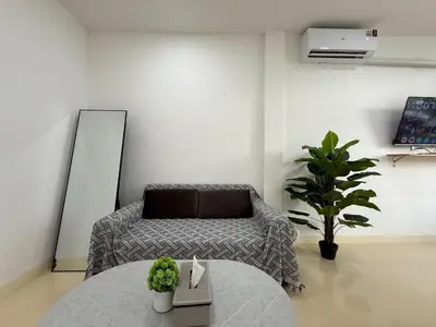 a living room with a table and a couch at Sukhumvit 48 separated room quiet and comfortable with fast internet and smart TV in Bangkok