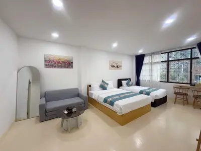 a bedroom with two beds and a chair in it at Sukhumvit 48 separated room quiet and comfortable with fast internet and smart TV in Bangkok