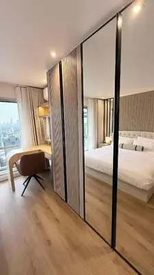a bedroom with a bed and a desk and a mirror at Your Urban Oasis in the Heart of Sukhumvit in Bangkok