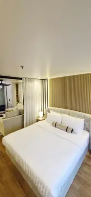 a bedroom with a large white bed and a couch at Your Urban Oasis in the Heart of Sukhumvit in Bangkok