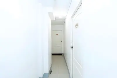 a hallway with white walls and a white door at XX Oh My Nap Sukhumvit 3 - Nana Bangkok in Makkasan