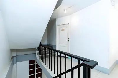 a staircase with black railings and a white door at XX Oh My Nap Sukhumvit 3 - Nana Bangkok in Makkasan