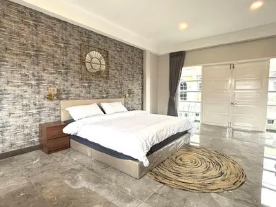 a bedroom with a bed and a brick wall at House in the heart of Thonglor, Bangkok, 8 min to BTS in Bangkok