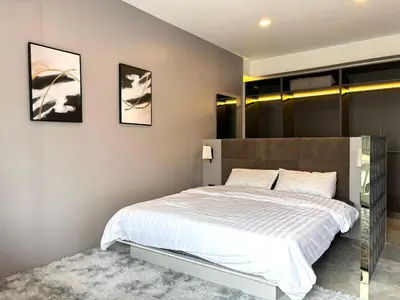 a bedroom with a large white bed and two pictures on the wall at House in the heart of Thonglor, Bangkok, 8 min to BTS in Bangkok