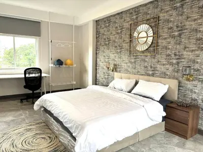 a bedroom with a bed and a clock on the wall at House in the heart of Thonglor, Bangkok, 8 min to BTS in Bangkok