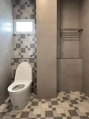 a bathroom with a toilet and a tile floor at House in the heart of Thonglor, Bangkok, 8 min to BTS in Bangkok
