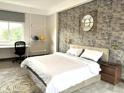 a bedroom with a large bed and a clock on the wall at House in the heart of Thonglor, Bangkok, 8 min to BTS in Bangkok