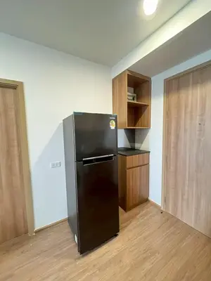 a kitchen with a black refrigerator in a room at Stay in near International airport in Bangkok