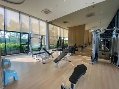 a gym with several treadmills and machines in a room at Stay in near International airport in Bangkok