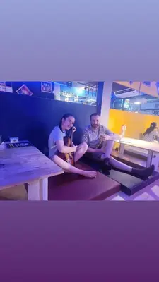 two people sitting on a table in a room at RoXx Social Hostel in Bangkok