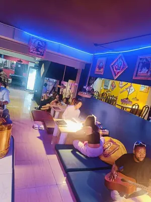 a group of people sitting on mats in a bar at RoXx Social Hostel in Bangkok