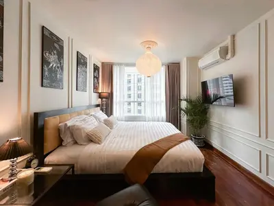 a bedroom with a large bed and a window at Prime Classic 1 BR BTS Chidlom 72SQM Langsuan in Bangkok