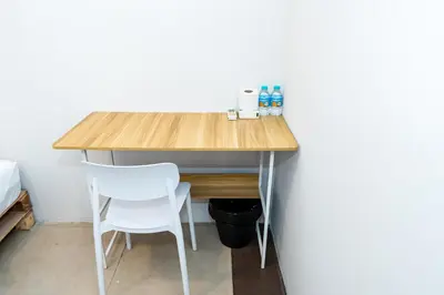a wooden desk with a white chair and a table at xx The Hidden Khaosan - Rambuttri เดอะ ฮิดเด้น ตรอกข้าวสาร รามบุตรี in Bang Bua Thong Railway Station
