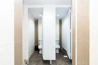 a bathroom with two toilets and two sinks at xx The Hidden Khaosan - Rambuttri เดอะ ฮิดเด้น ตรอกข้าวสาร รามบุตรี in Bang Bua Thong Railway Station