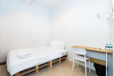 a bed in a room with a desk and a chair at xx The Hidden Khaosan - Rambuttri เดอะ ฮิดเด้น ตรอกข้าวสาร รามบุตรี in Bang Bua Thong Railway Station