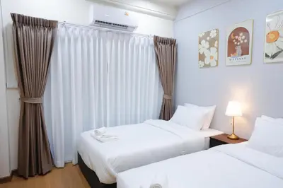 a hotel room with two beds and a window at CozyTwin Bed วิวระเบียง เจริญนคร in Bangkok