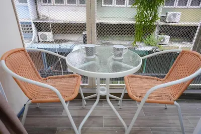 a table and two chairs with cups on a patio at CozyTwin Bed วิวระเบียง เจริญนคร in Bangkok