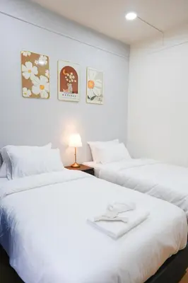 two beds in a room with white sheets at CozyTwin Bed วิวระเบียง เจริญนคร in Bangkok